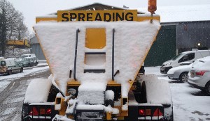 A Surrey gritter covered in snow after treating roads winter weather