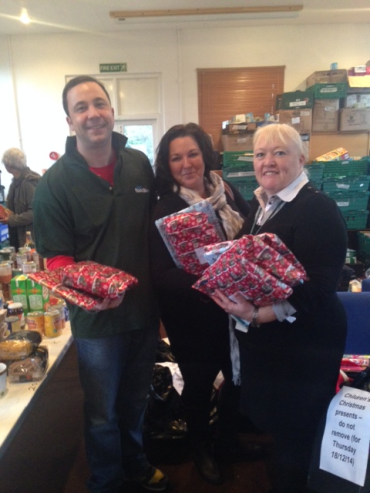 Adult Social Workers Cathy Heath and Kim Kurani deliver Christmas presents to Food Bank Manager Jonathan Lees.